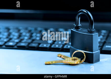 Lock on laptop keyboard with shallow depth of field toned in blue Stock Photo