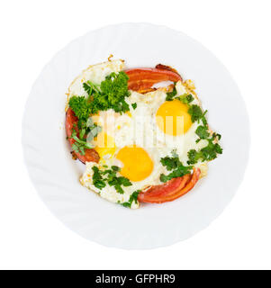 two fried eggs and tomato with herbs on plate isolated top view Stock Photo