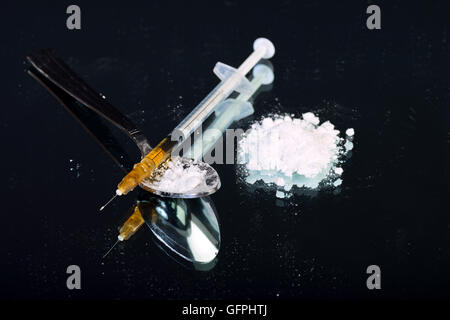 Drug syringe and white powder on spoon Stock Photo