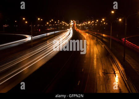 A night time shot of speeding traffic on a road Stock Photo