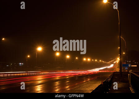 A night time shot of speeding traffic on a road Stock Photo