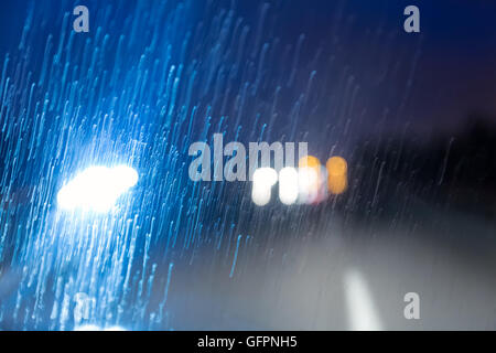 road in rain through windscreen of moving car Stock Photo