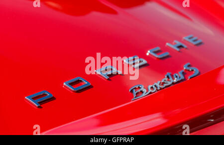 Close up shot of a Porsche badge on a red car Stock Photo
