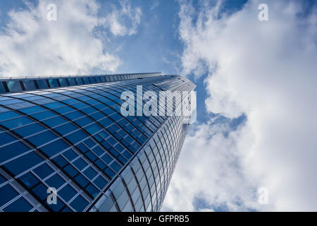 Looking up at a tall building with an cloudy sky above Stock Photo