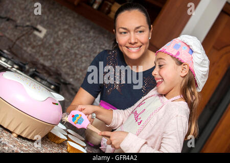 Preparing cupcakes with mom Stock Photo