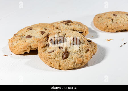 crispy cookies with chocolate and nuts on a white wooden table Stock Photo