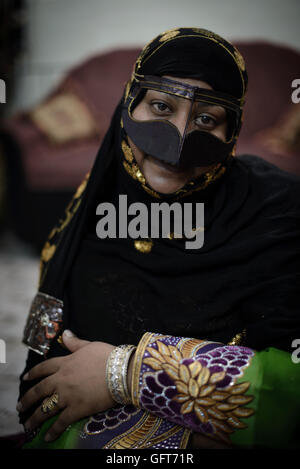 Local woman posing with her traditional hand made clothes and burqa at her home. Hormuz Island, Hormozgan province, Iran Stock Photo