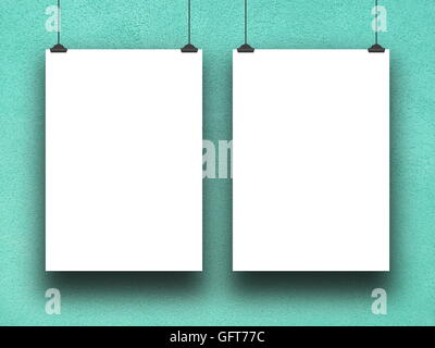 Close-up of two blank square frames hanged by clips against aqua rough plaster wall background Stock Photo