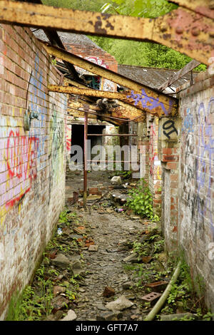 Graffiti and vandalism in abandoned derelict industrial building. Stock Photo