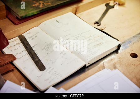 A furniture workshop Hand written notes in a notebook on a workbench Stock Photo