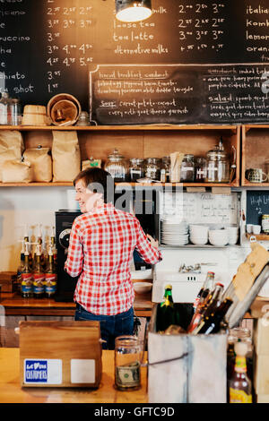 A woman working behind the counter in a coffee shop Business owner Stock Photo
