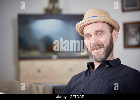 Happy man portrait sitting at home in front of aquarium Stock Photo