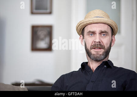 Friendly man with hat and beard portrait at home Stock Photo