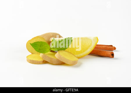 sliced ginger with lemon and cinnamon sticks on white background Stock Photo