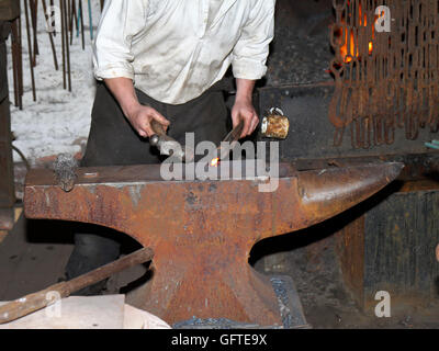 Blacksmith working with molten metal in a Vice Stock Photo