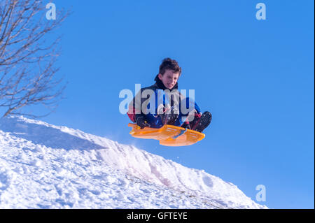 Children sledging at Brighton's Stanmer Park after a pre-Christmas snowfall. Stock Photo