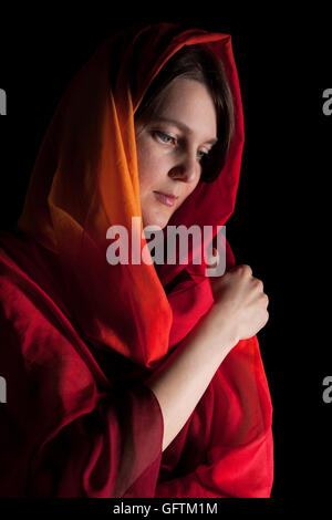Woman in red headscarf isolated on black background Stock Photo