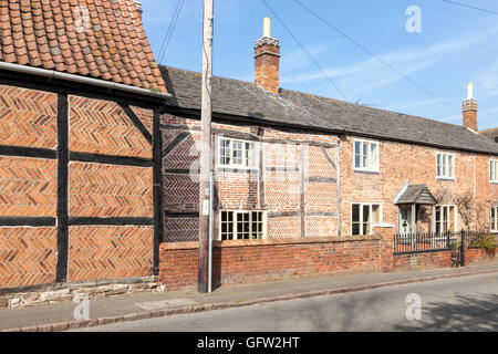 Various brickwork patterns, including herringbone, on a timber framed cottage and other buildings, Hoton, Leicestershire, England, UK Stock Photo