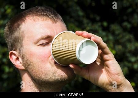 Man drinking a take away coffee from a paper cup Stock Photo