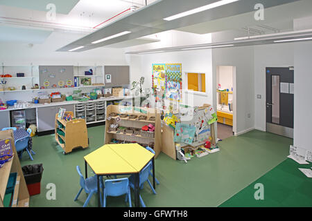 Nursery classroom in a new, London primary school. Shows desks and chairs with pupil's artwork on the walls Stock Photo