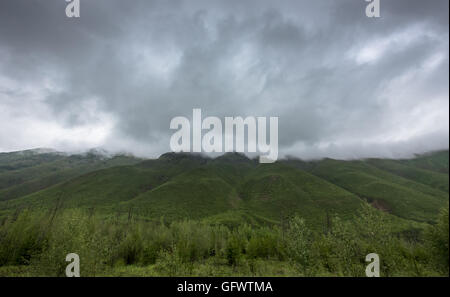 Thick Rain Clouds Over Green Mountains on a rainy summer day Stock Photo