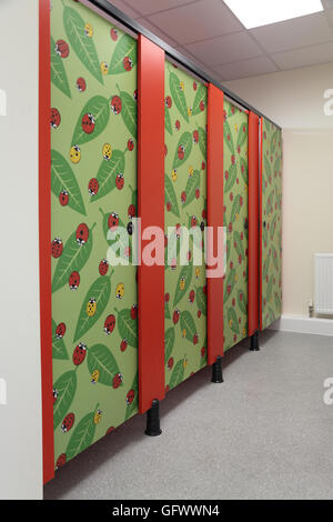 Toilet cubicle doors in a new primary school decorated with a distinctive ladybird design Stock Photo