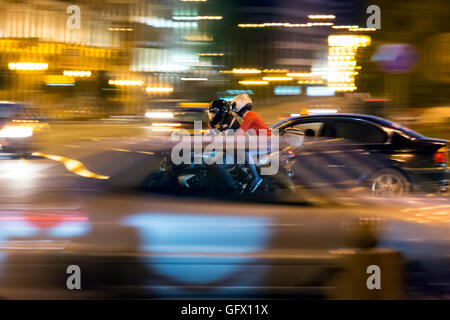 Man and woman on motorcycle at night in city Stock Photo