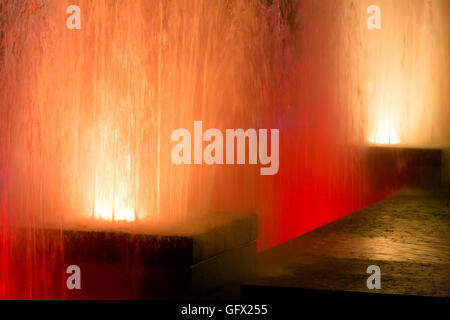Orange fountains glow in the night Stock Photo