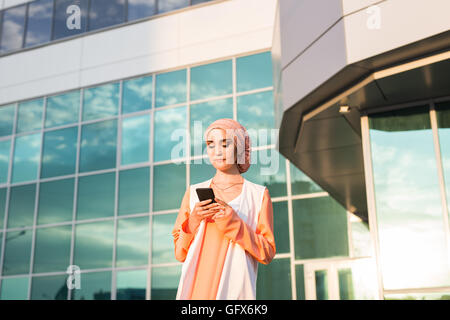 Muslim woman using phone Stock Photo