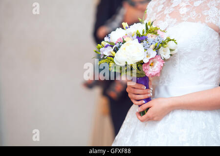 Close view of beautiful colorful wedding bouquet in a hand of a bride Stock Photo
