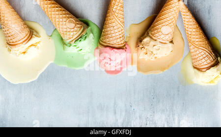 Colorful ice cream cones of different flavors. Melting scoops. Top view,  steel metal background Stock Photo