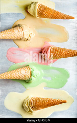 Colorful ice cream cones of different flavors. Melting scoops. Top view,  steel metal background. Stock Photo