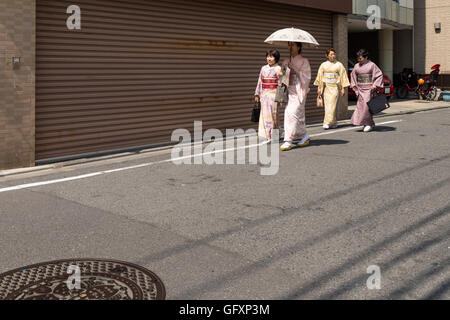 Japanese women dressed up in traditional clothes and walking on the side of a small street close Ueno park in Tokyo. Stock Photo