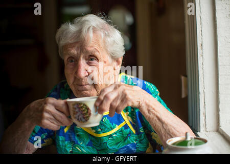 Elderly woman alone drinking tea. Stock Photo