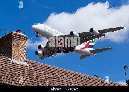 Emirates Airbus / Air Bus A380-861 A6-EEA plane landing over roof tops at London airport. Stock Photo