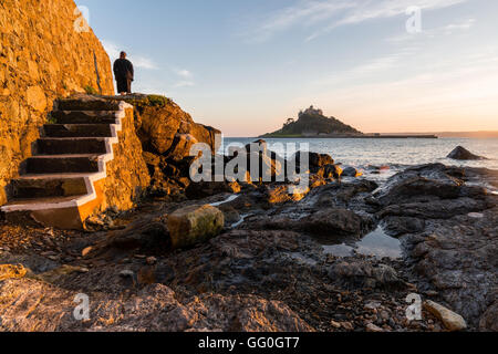 Lady stand on the shore to watch St Michael Mount Stock Photo