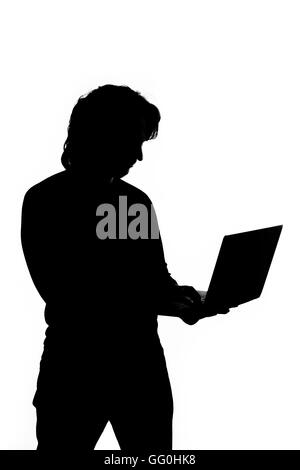 Silhouette of a man holding laptop Stock Photo