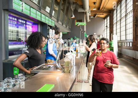 Steam Whistle Brewing, Toronto, Ontario, Canada - woman tasting a free sample of craft beer - a Pilsner - inside the brewery Stock Photo