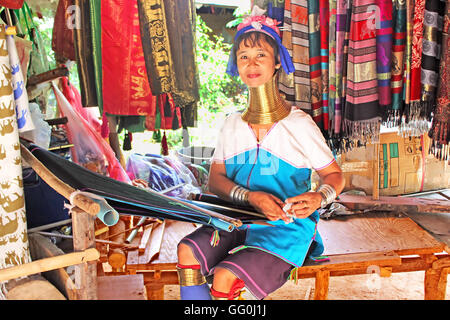 MAE HONG SON, THAILAND - JUNE 17, 2014: Unidentified Padaung (Karen) tribe woman weave on traditional device near Mae Hong Son Stock Photo