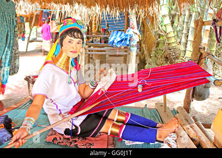 MAE HONG SON, THAILAND - JUNE 17, 2014: Unidentified Padaung (Karen) tribe woman weave on traditional device near Mae Hong Son Stock Photo