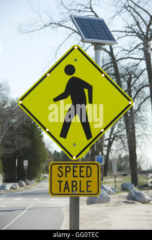 Speed table pedestrian crossing sign with solar powered flashers illuminated.