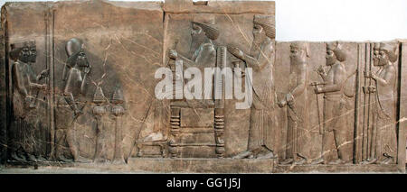 227. LIMESTONE RELIEF OF KING DARIUS SEATED ON THRONE, CROWN PRINCE XERXES, GUARDS AND ATENDANTS  BEHIND HIM.  PERSEPOLIS, CA. 5 Stock Photo