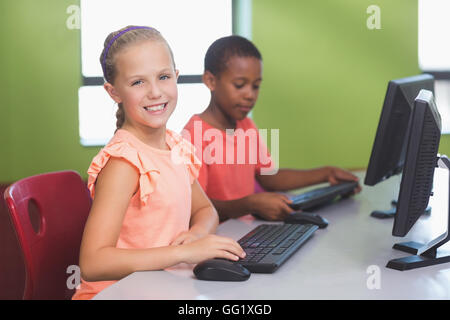 School kids using computer in classroom Stock Photo