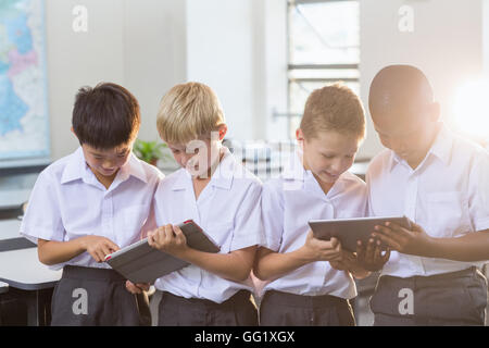 Students using digital tablet in classroom Stock Photo