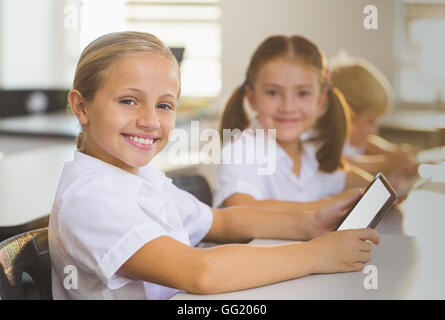 School girls using digital tablet in classroom Stock Photo