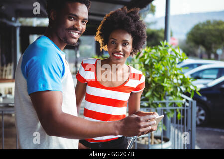 Portrait of smiling couple using mobile phone Stock Photo