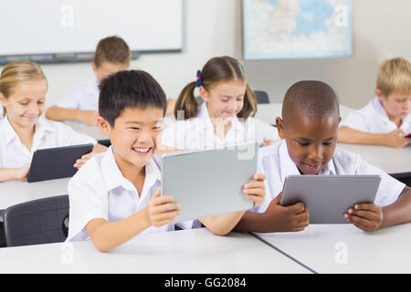 School kids using digital tablet in classroom Stock Photo