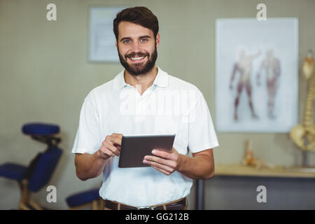 Male therapist holding digital tablet in clinic Stock Photo