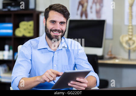 Male therapist using digital tablet in clinic Stock Photo