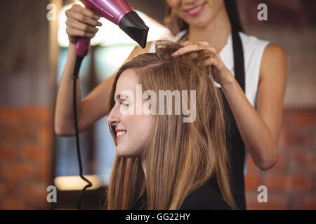 Hairdresser styling customers hair Stock Photo